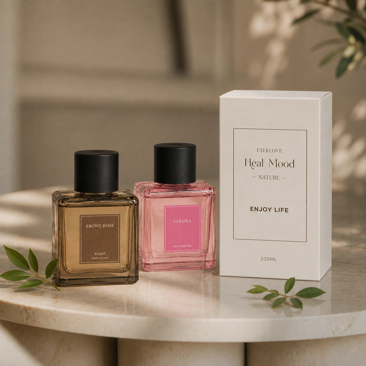EterLove Plume automatic scent diffuser with Ebony Rose and Sakura fragrance bottles beside packaging in a warm home setting.
