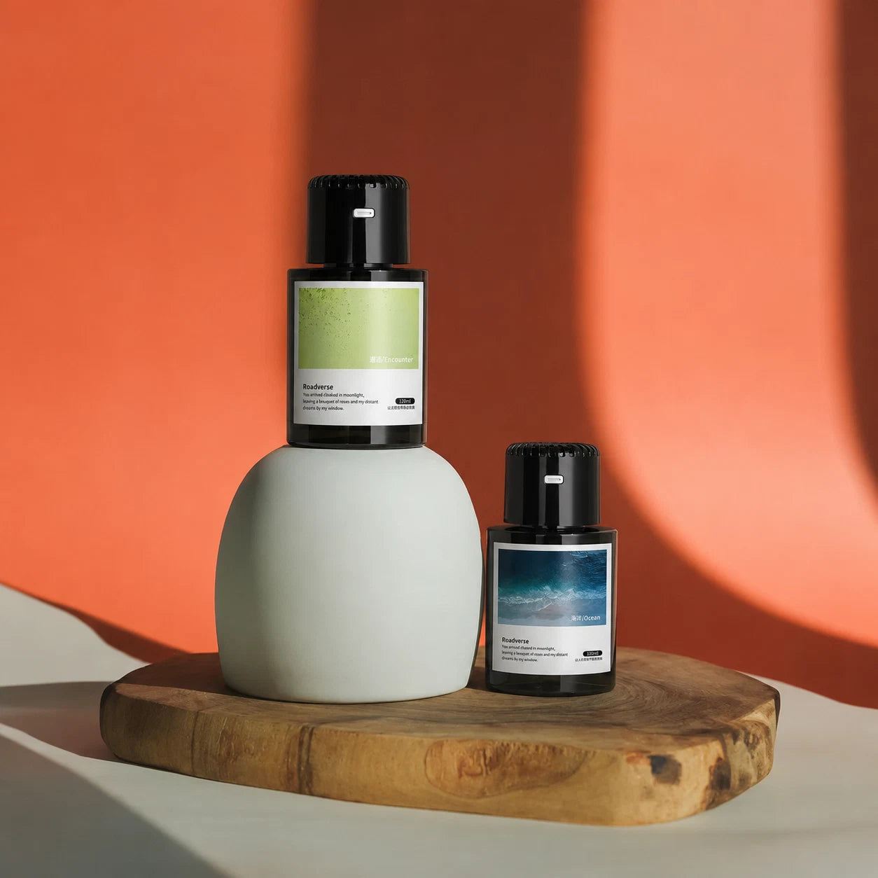 EterLove Plume car scent diffuser displayed with fragrance refill bottles on a wooden tray against a warm orange background.